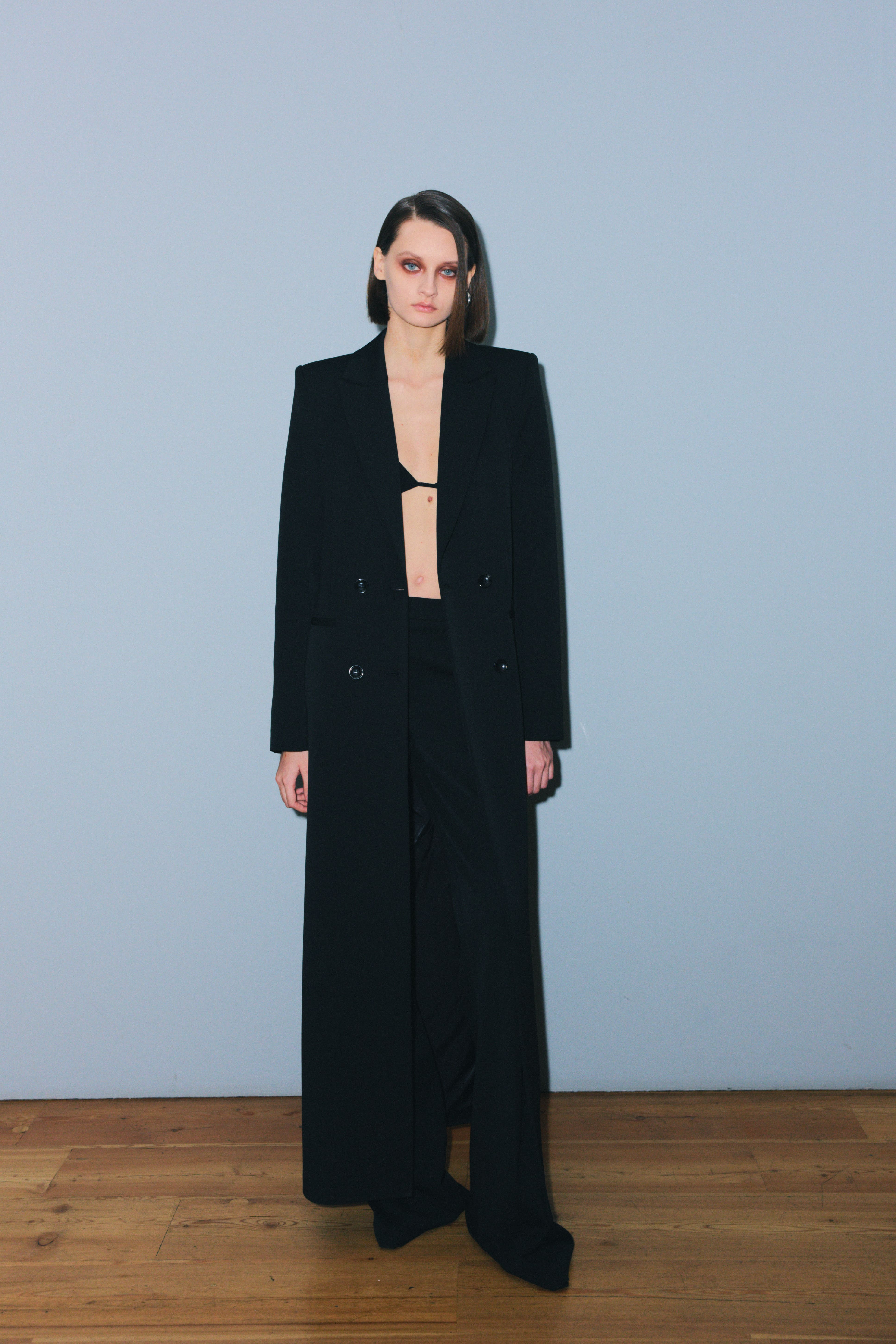 Элегантный черный костюм от Juliawave с длинным пиджаком и открытым топом, создающий контраст между строгостью и сексуальностью.