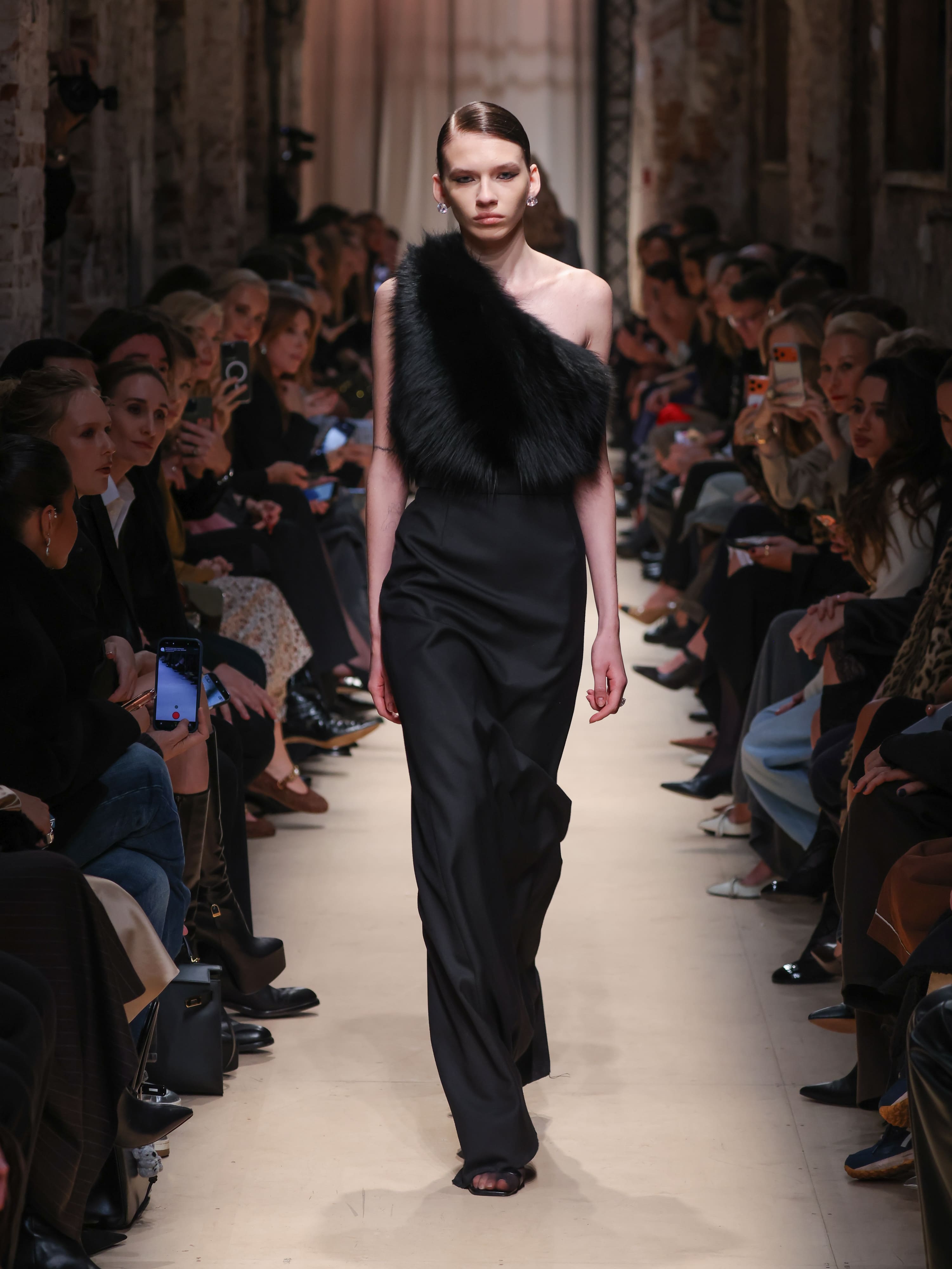 Элегантное черное платье с асимметричным верхом, украшенным мехом, создает атмосферу утонченной роскоши на показе Sashaverse осень-зима 2026.