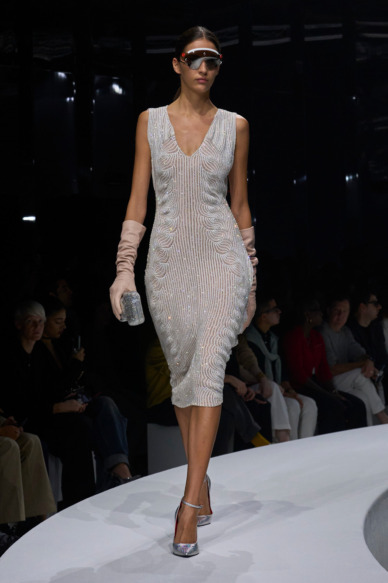 Сияющее платье с волнистым узором из пайеток, дополненное длинными персиковыми перчатками и металлическими туфлями на каблуке.