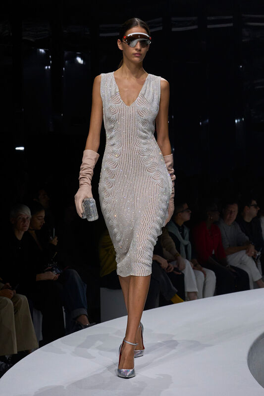 Сияющее платье с волнистым узором из пайеток, дополненное длинными персиковыми перчатками и металлическими туфлями на каблуке.