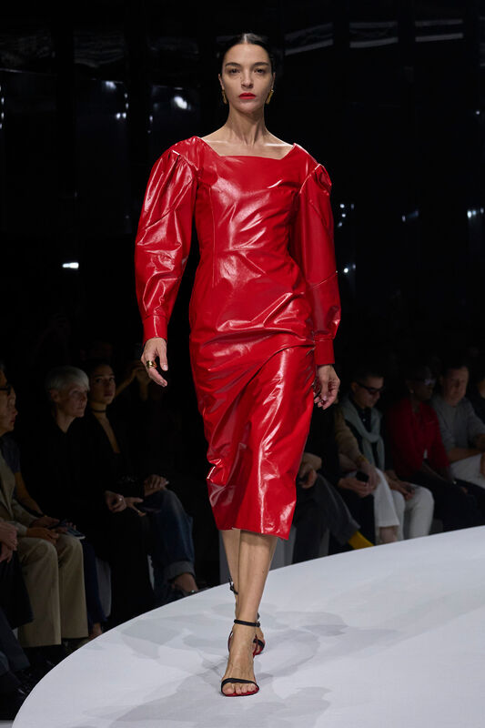 Яркое красное платье из лакированной кожи с объемными рукавами, подчеркивающее силуэт, создает эффектный образ для весны/лета 2024 от Ferrari