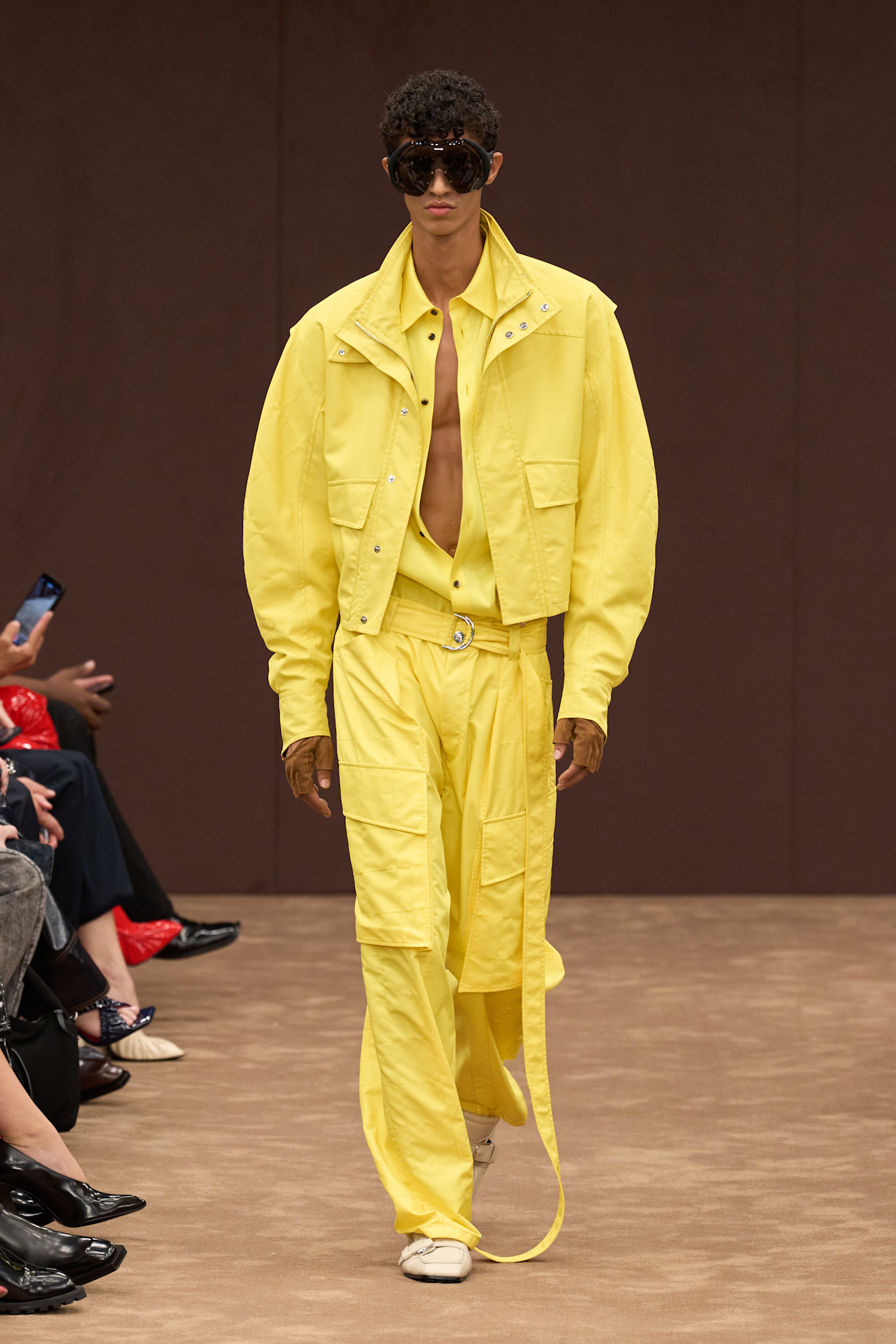 Яркий желтый комплект из легкой ткани с объемной курткой и широкими брюками, дополненный эффектными очками, создает атмосферу летнего шика....