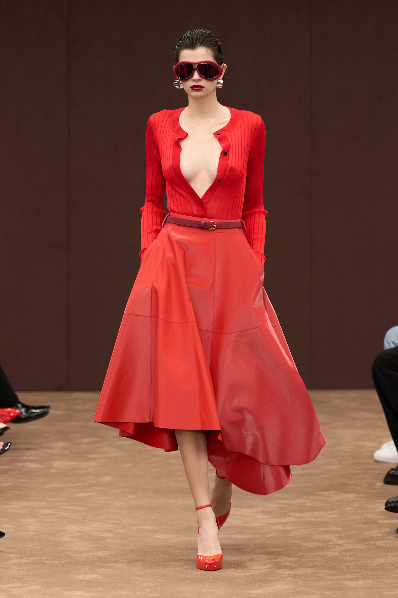 Яркий образ от Ferrari: облегающий красный топ с глубоким вырезом и струящаяся юбка из лакированной кожи, дополненные стильными аксессуарами.