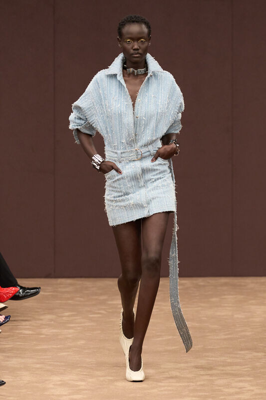 Легкий джинсовый мини-платье нежно-голубого оттенка с объемными рукавами и асимметричным подолом, дополненное стильными аксессуарами.