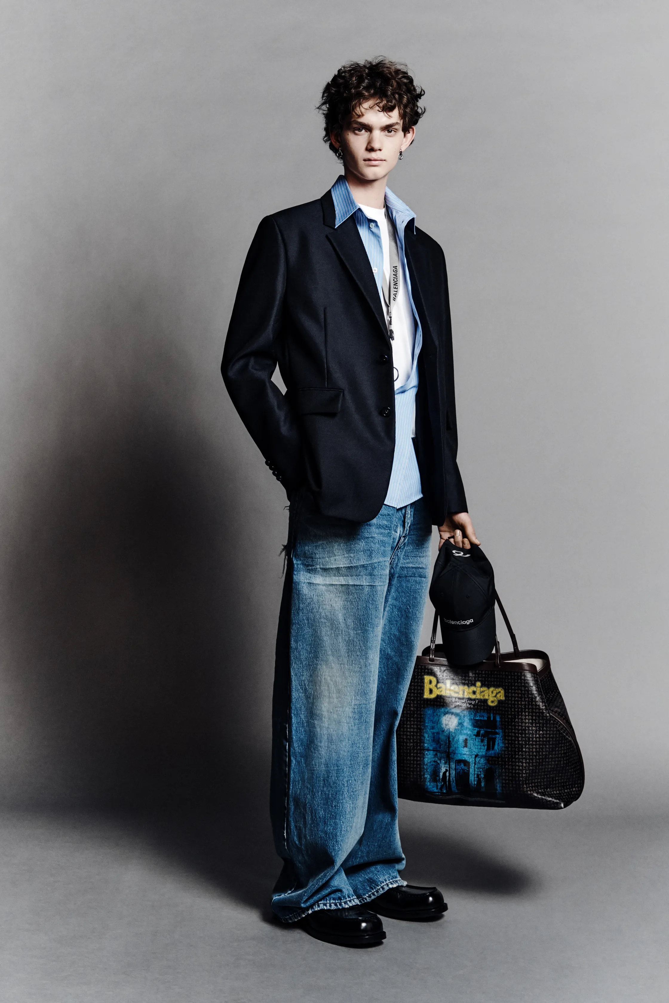 Классический пиджак в сочетании с неформальной рубашкой и широкими джинсами, завершенный стильной сумкой и кепкой, создает расслабленный, но элегантный вид