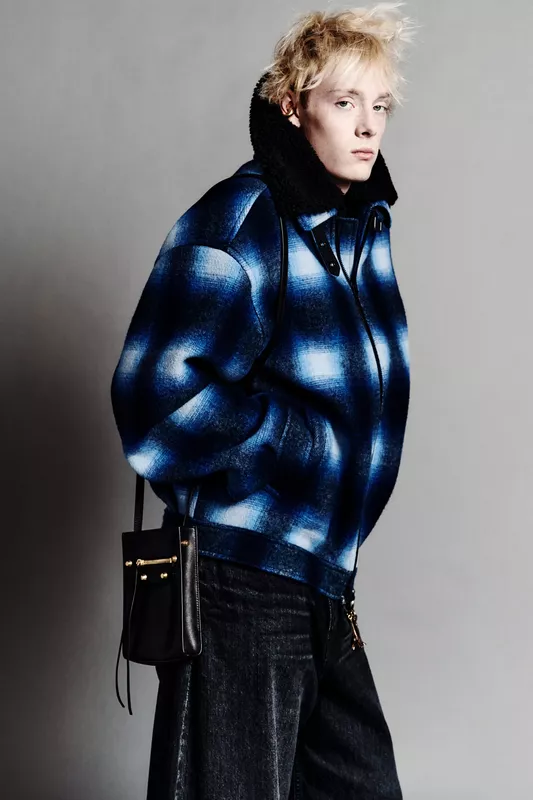 Пуховик в клетку с яркими синими оттенками и черной сумкой добавляют дерзости в образ, акцентируя внимание на текстуре