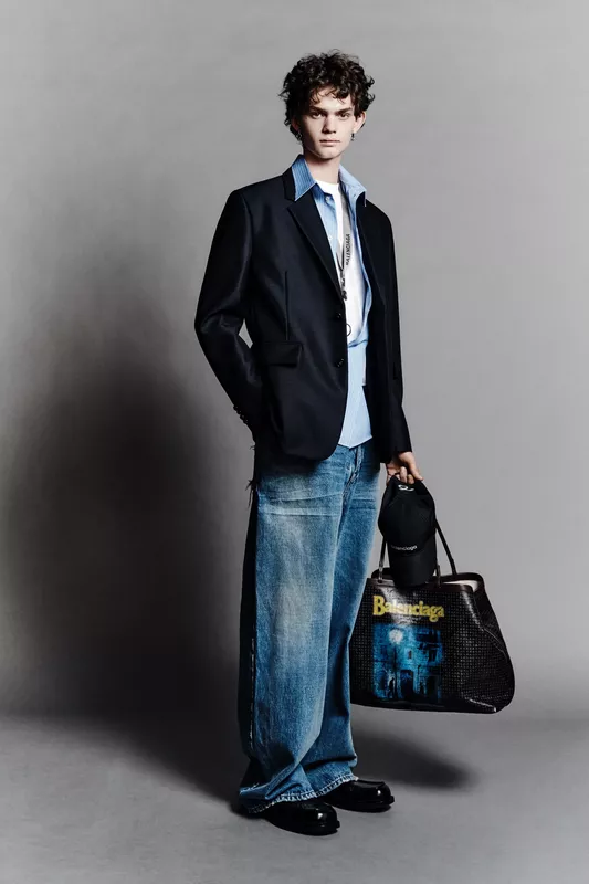 Классический пиджак в сочетании с неформальной рубашкой и широкими джинсами, завершенный стильной сумкой и кепкой, создает расслабленный, но элегантный вид