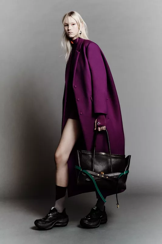 Яркий пурпурный пальто Balenciaga в сочетании с черной сумкой и массивными кроссовками создает эффектный образ для осени 2026