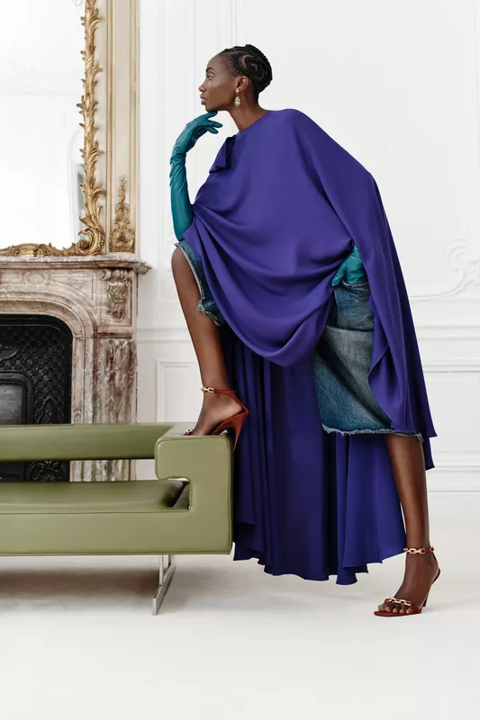 Длинное фиолетовое пончо в сочетании с джинсовой юбкой, яркие перчатки и изысканные серьги создают эффектный образ