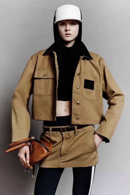 Короткая куртка цвета хаки с черным капюшоном и стильной сумкой, создающая современный образ для осени