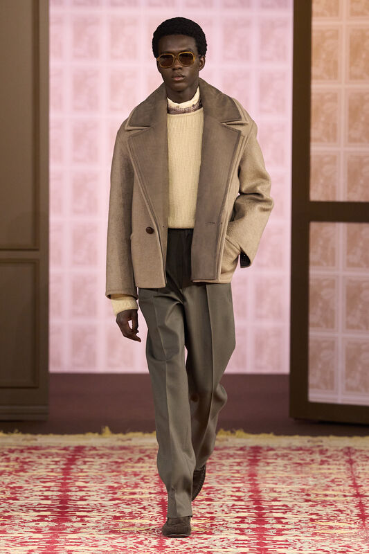 Модель в объемном бежевом пальто и светлом свитере, дополненная стильными очками, создает атмосферу уюта и элегантности