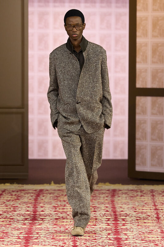 Элегантный костюм из текстурной ткани с блеском, дополненный очками, передает атмосферу утонченной строгости