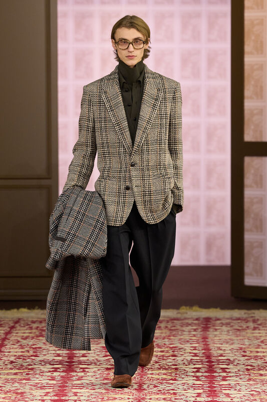 Элегантный образ в клетчатом пиджаке и черной рубашке, дополняемый стильными очками и классическими брюками