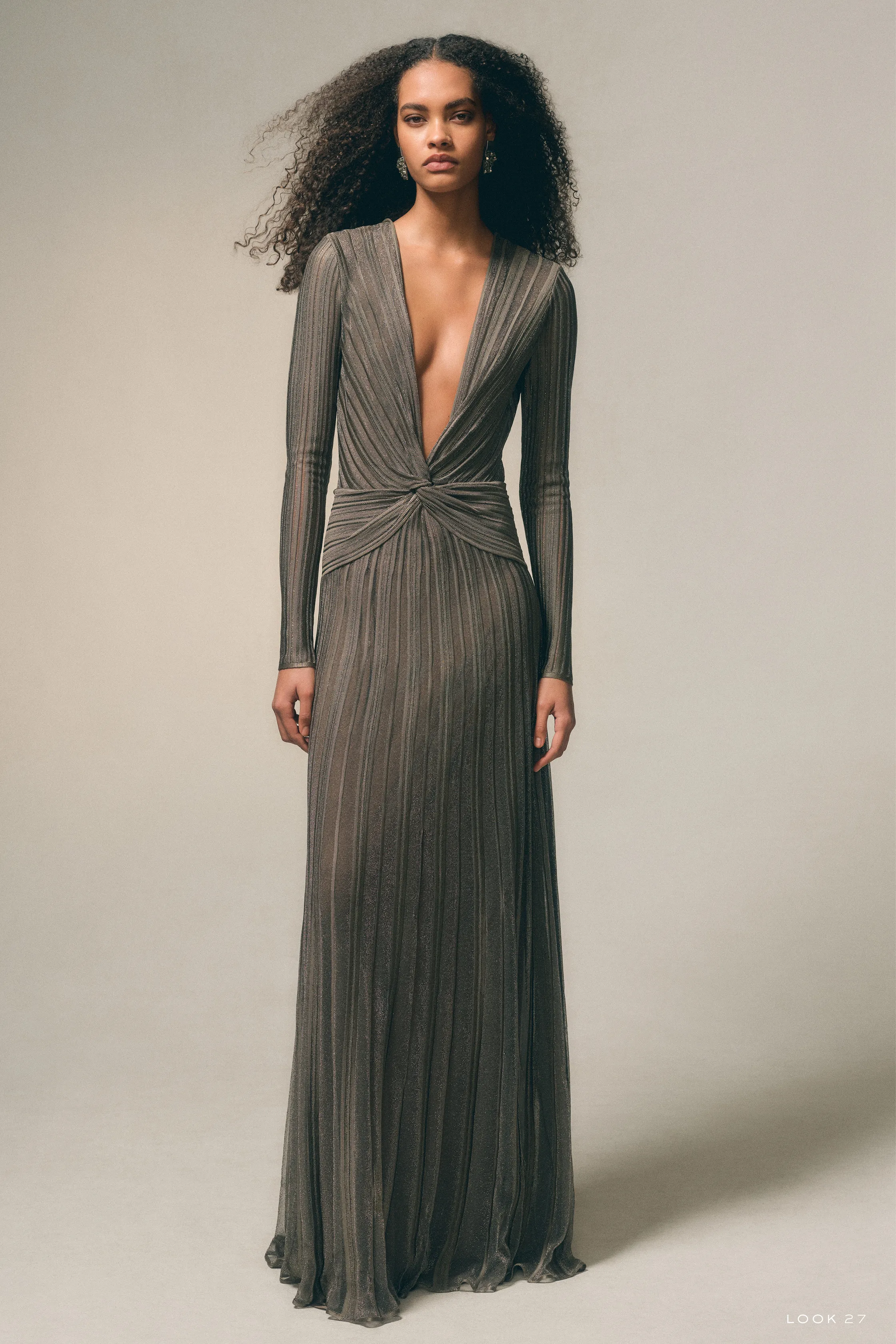 Платье с глубоким вырезом и складками, выполненное в нежном оттенке, излучает элегантность и женственность