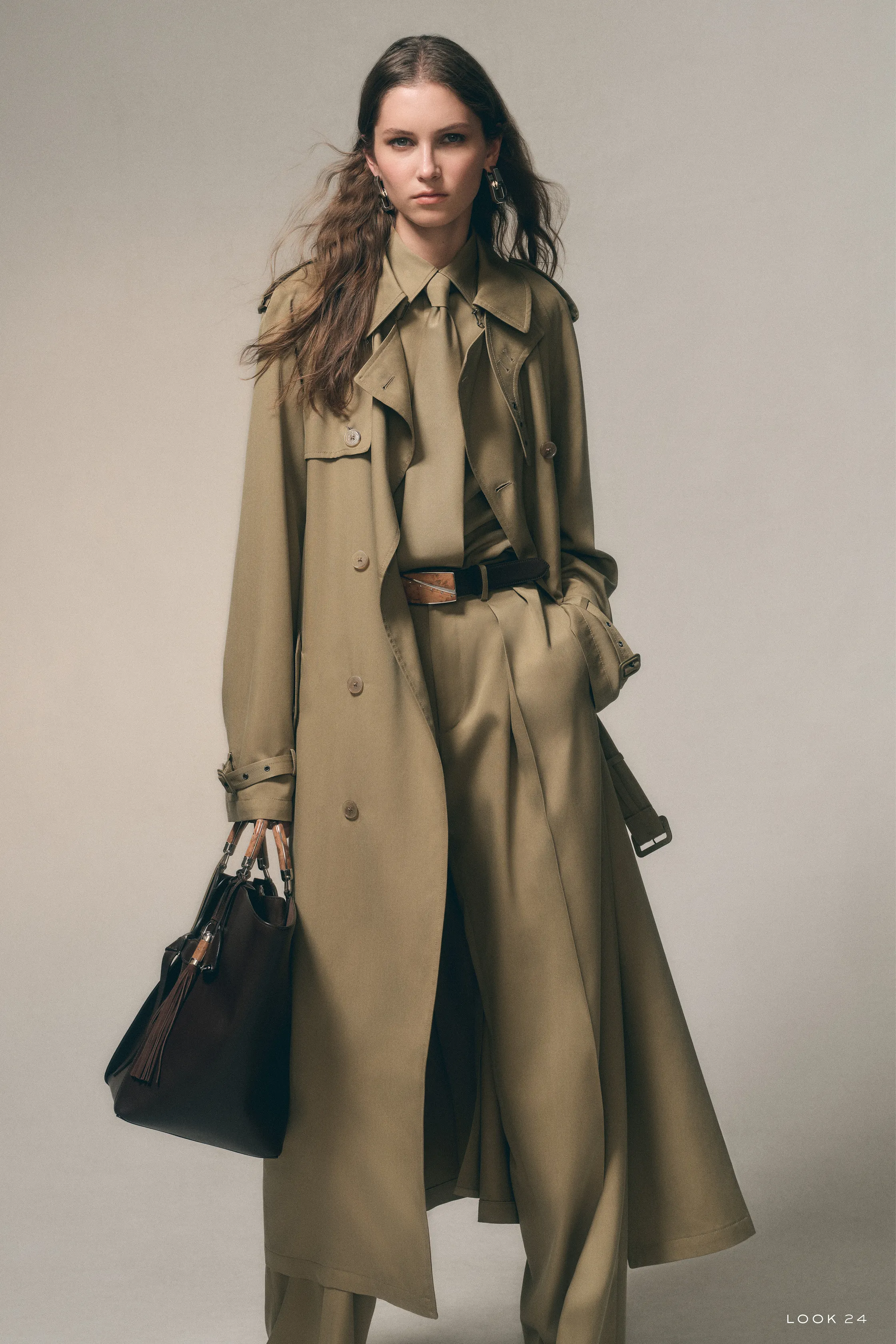 Элегантный оливковый тренч с рюшами и широкими брюками, дополненный стильной сумкой, подчеркивает уверенность