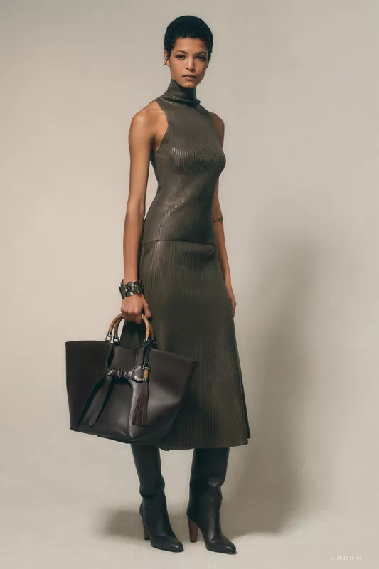 Обтягивающее платье с высоким воротником и кожаная сумка, создающие современный и изысканный силуэт