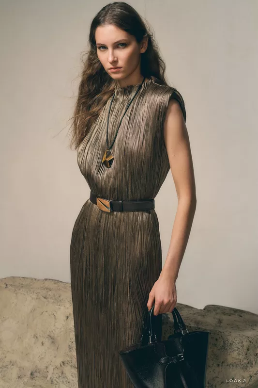 Платье с вертикальными складками и акцентным ожерельем, подчеркивающее изысканность и текстуру ткани
