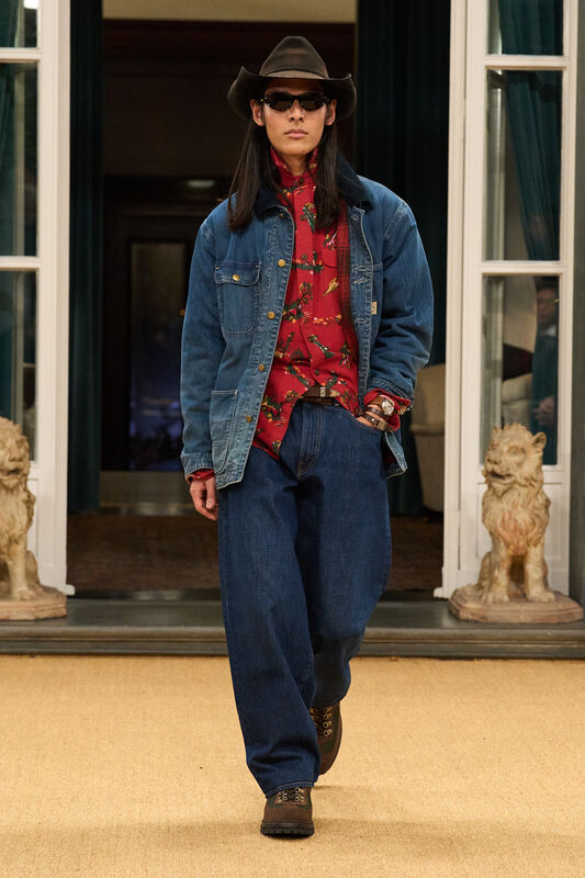 Джинсовая куртка и рубашка с цветочным принтом в сочетании с широкими брюками и ковбойской шляпой подчеркивают стильный кантри-образ