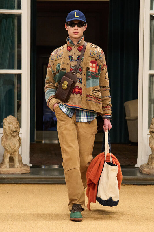 Уютный свитер с узором и светлые брюки, дополненные сумкой и оранжевым свитером, создают стильный кэжуал