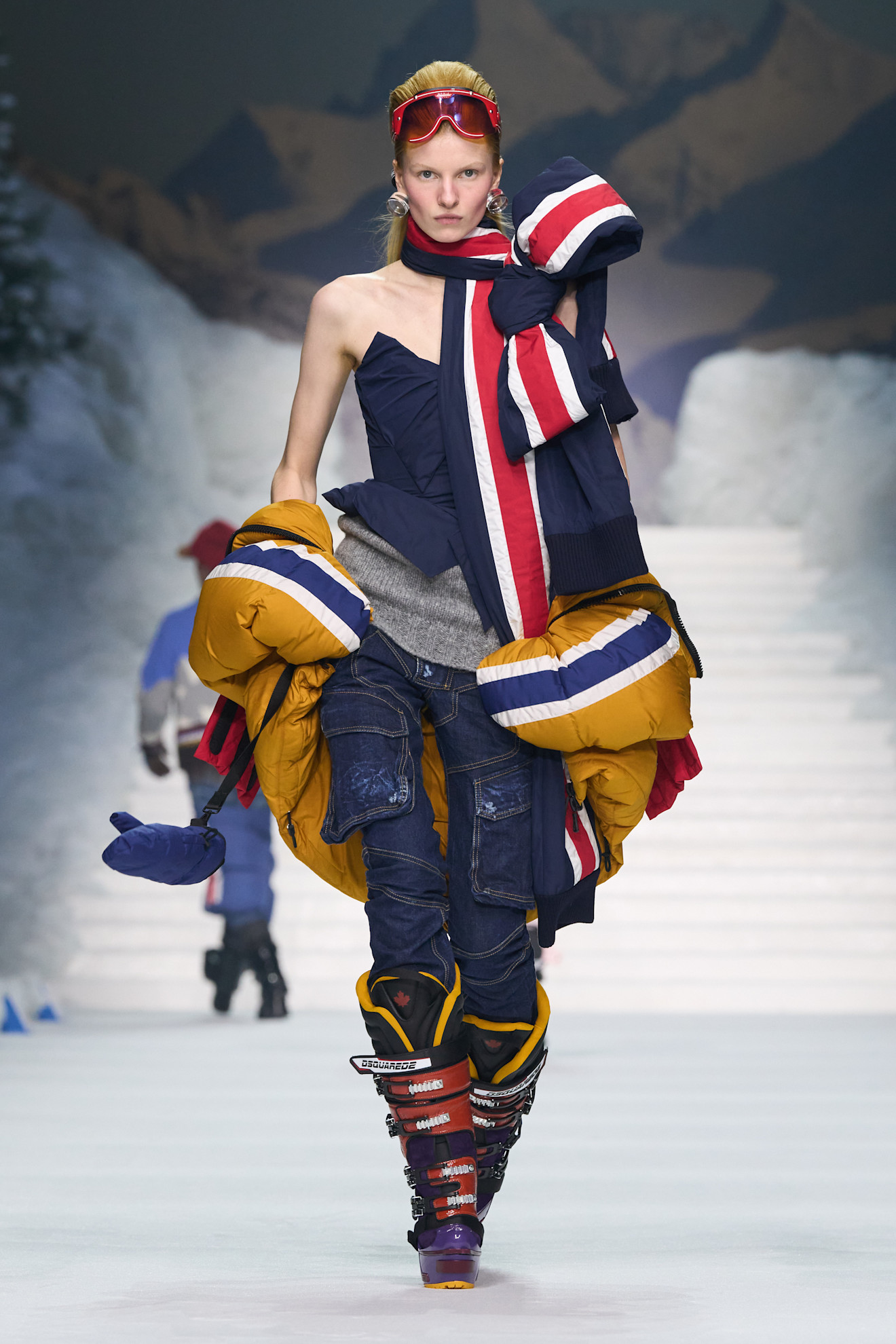 Эффектный образ с асимметричным верхом и ярким пуховиком, дополненный стильными лыжными очками