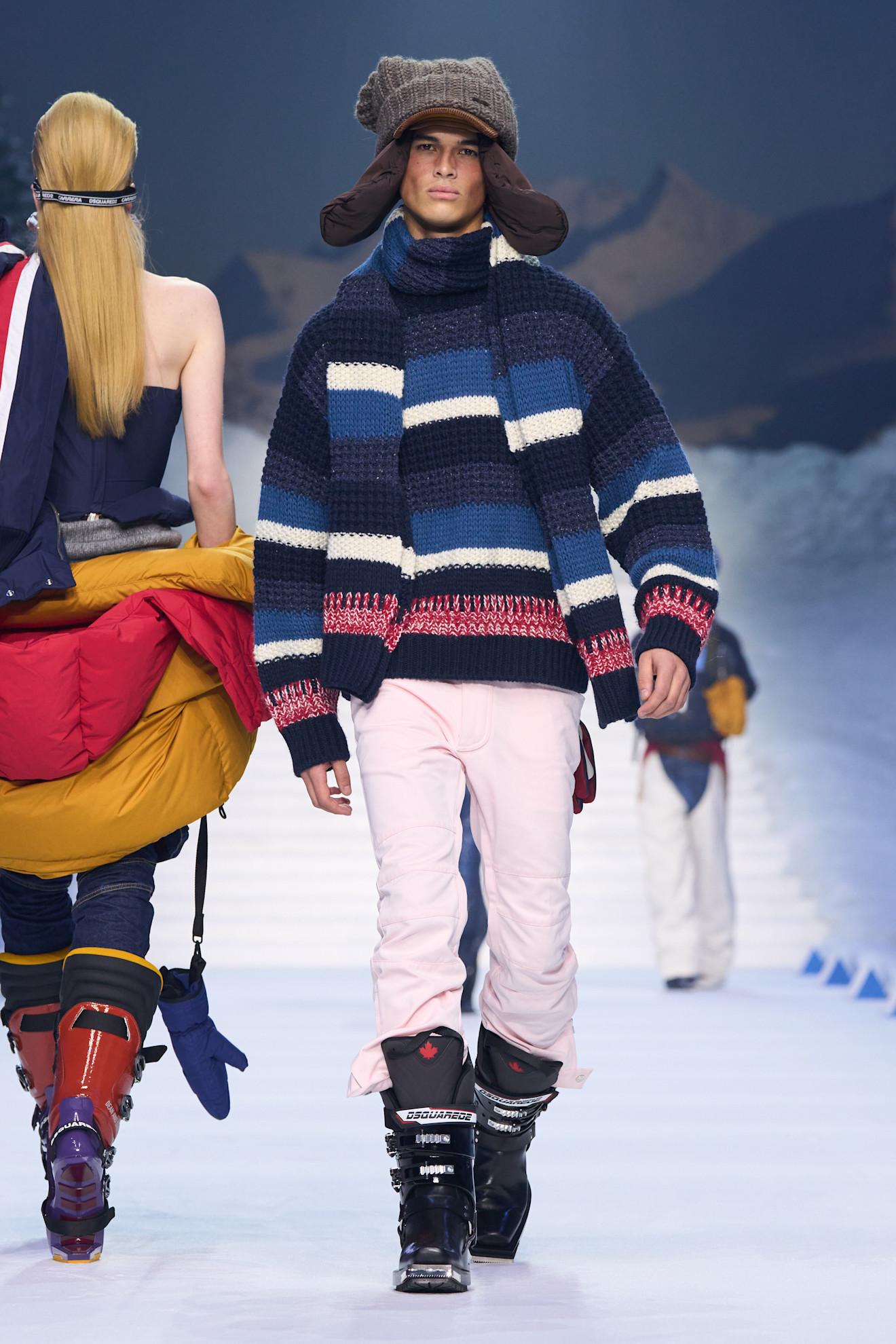 Стильный свитер в полоску и розовые брюки, подчеркивающие уютный зимний образ с шапкой-ушанкой