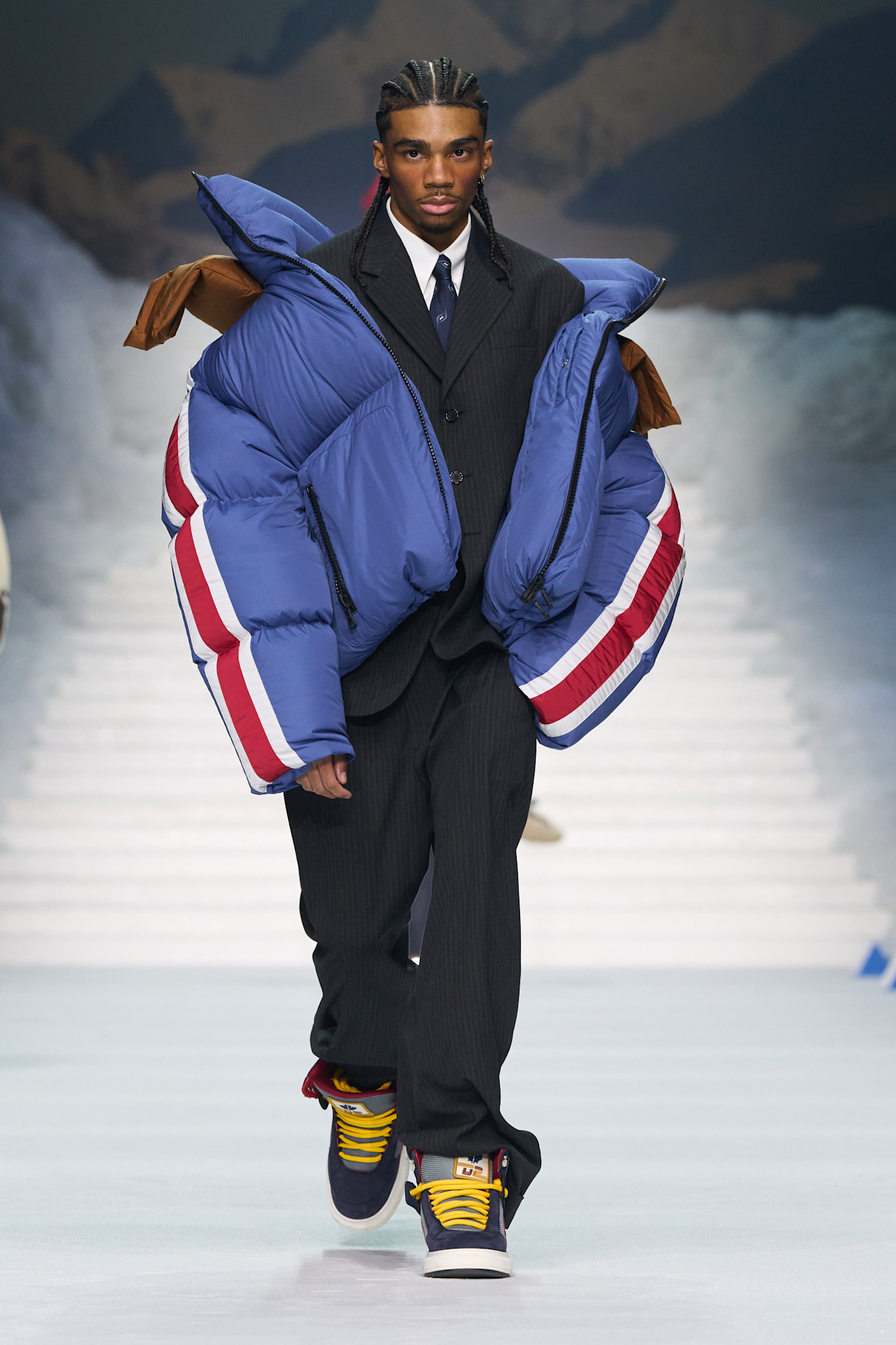 Элегантный костюм с пуховиком в ярких цветах и кроссовками создает смелый контраст между формальным и спортивным стилем