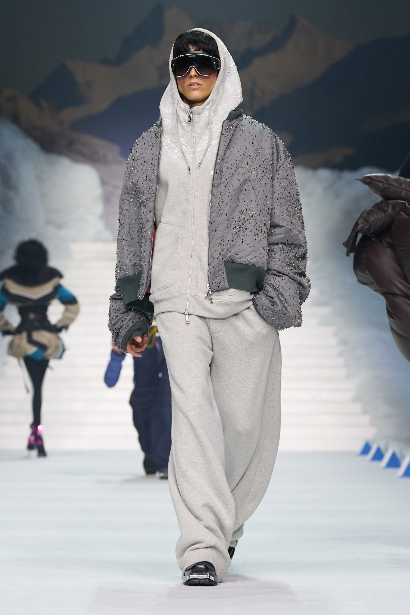 Серый спортивный костюм с блестящей курткой и крупными очками, сочетание комфорта и стиля для зимних прогулок
