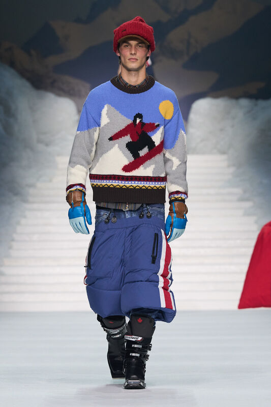 Модель в свитере с зимним принтом и яркой шапке, сочетает комфорт и стиль с объемными брюками и перчатками