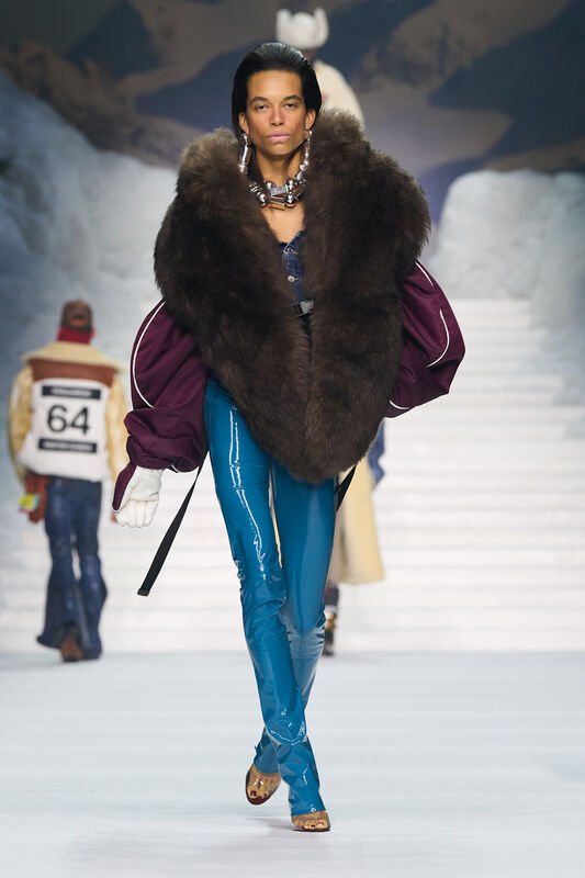 Объемный меховой палантин в сочетании с блестящими синими брюками и массивными украшениями создает эффектный зимний образ