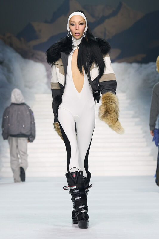 Элегантный комбинезон с глубоким вырезом и меховыми акцентами в сочетании с курткой придают образу динамичность и стиль.