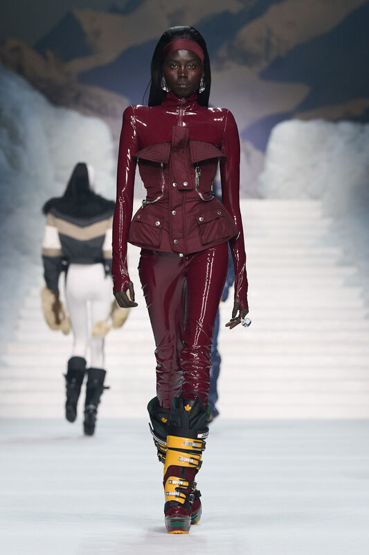 Лакированный костюм бордового цвета с оригинальными деталями подчеркивает силуэт и привлекает внимание к аксессуарам.