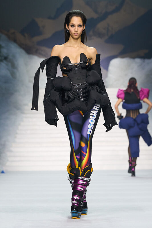 Модель в черном корсете и объемной куртке, дополненной яркими леггинсами и лыжными ботинками, создает смелый зимний look