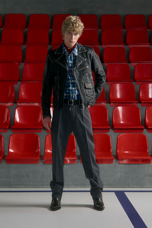 Кожаная куртка с заклепками и клетчатая рубашка, создающие дерзкий стиль на фоне ярких сидений