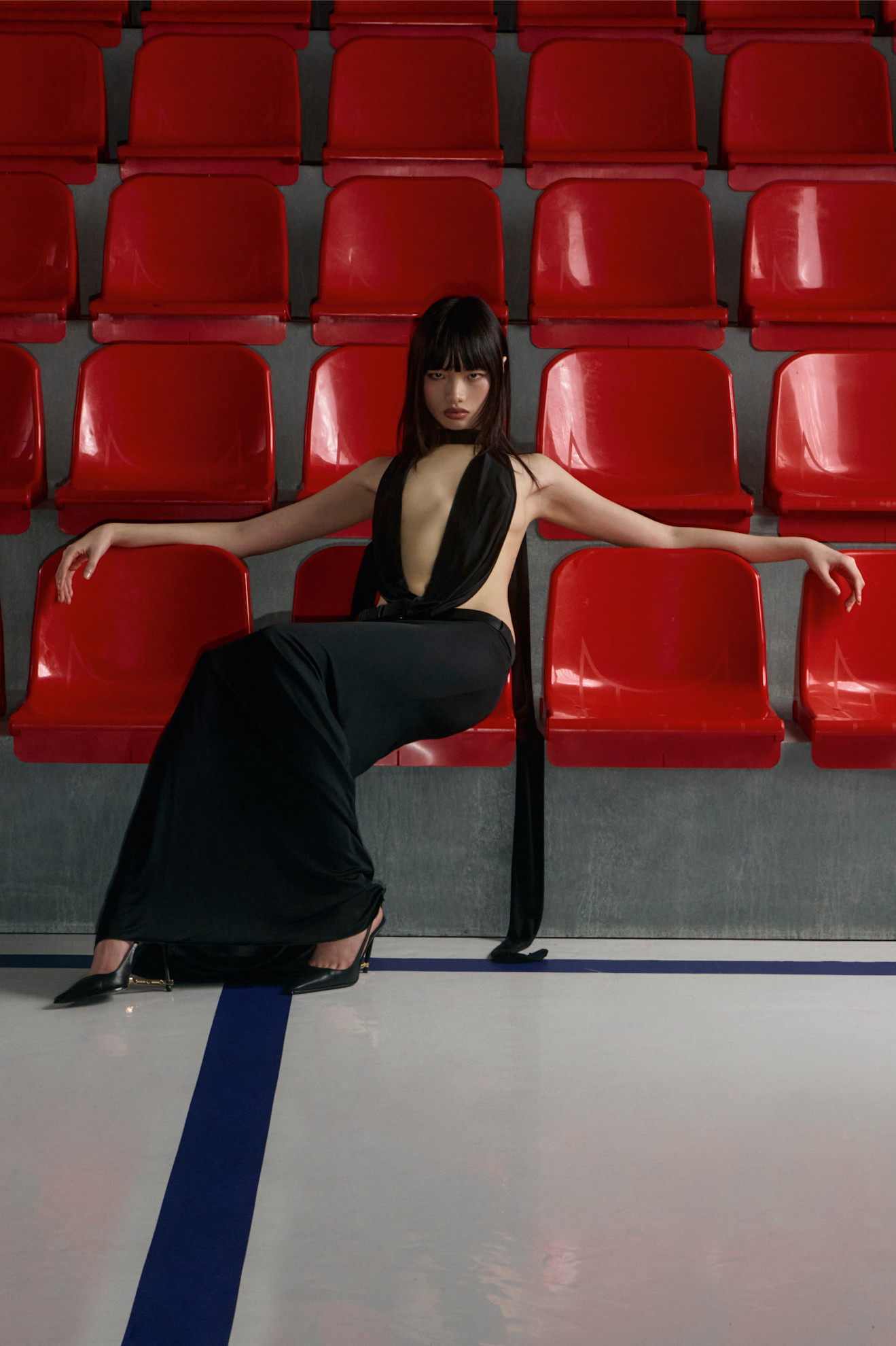 Платье с глубоким вырезом и длинными лентами, подчеркивающее фигуру, завершает образ стильная обувь на каблуке