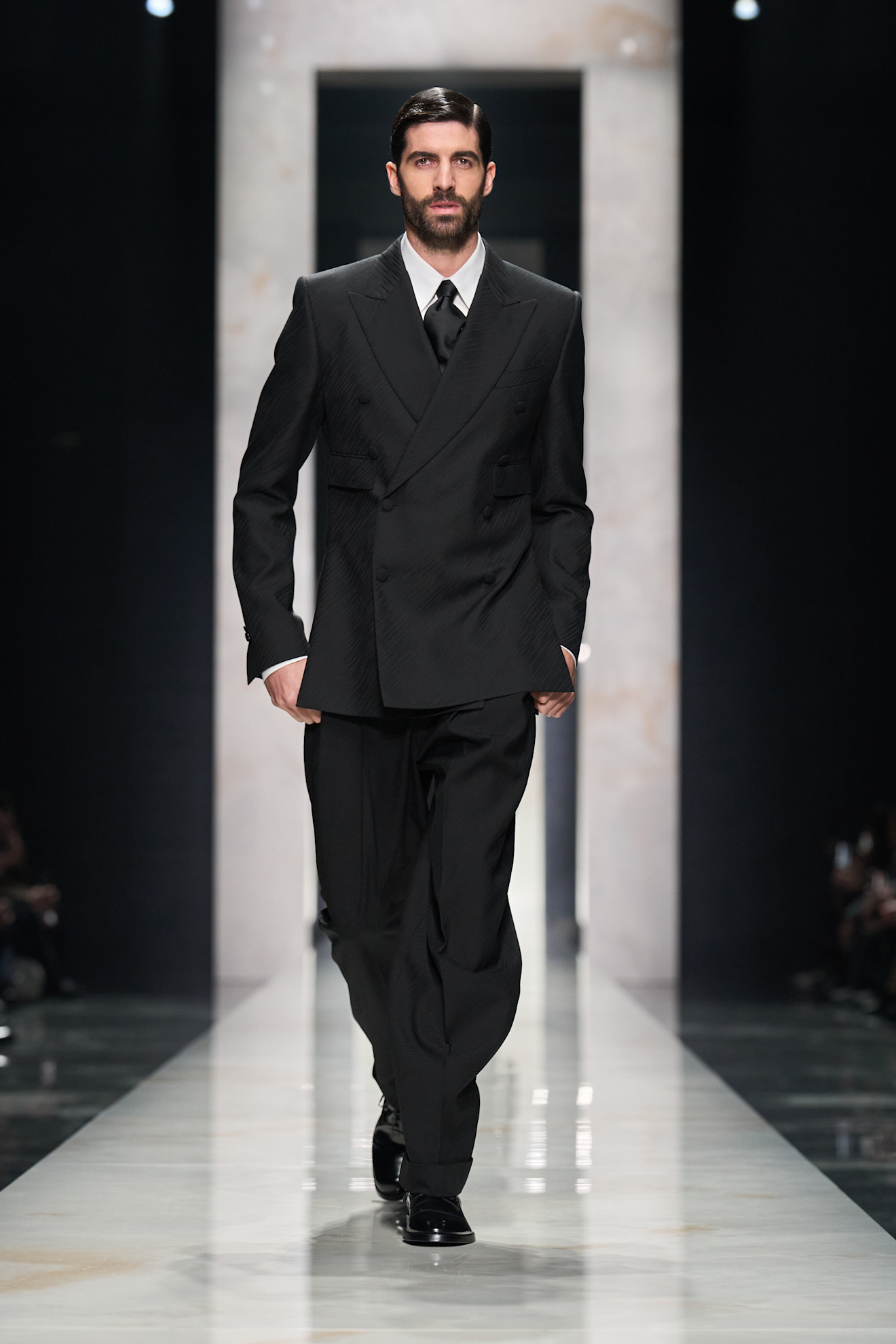 Двойной черный пиджак с текстурой и широкими брюками, создающий эффект мощного силуэта и уверенности