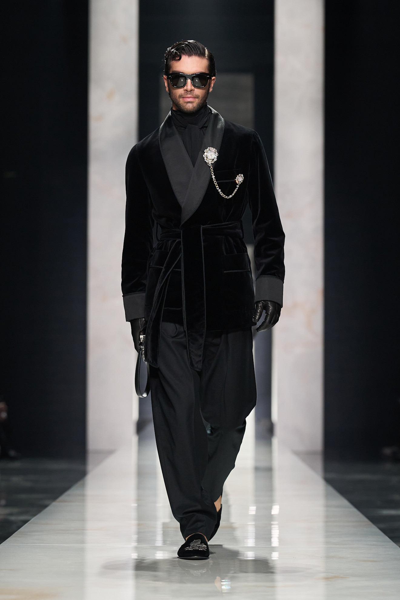 Элегантный черный бархатный халат с атласными деталями, дополненный стильной брошью и темными очками