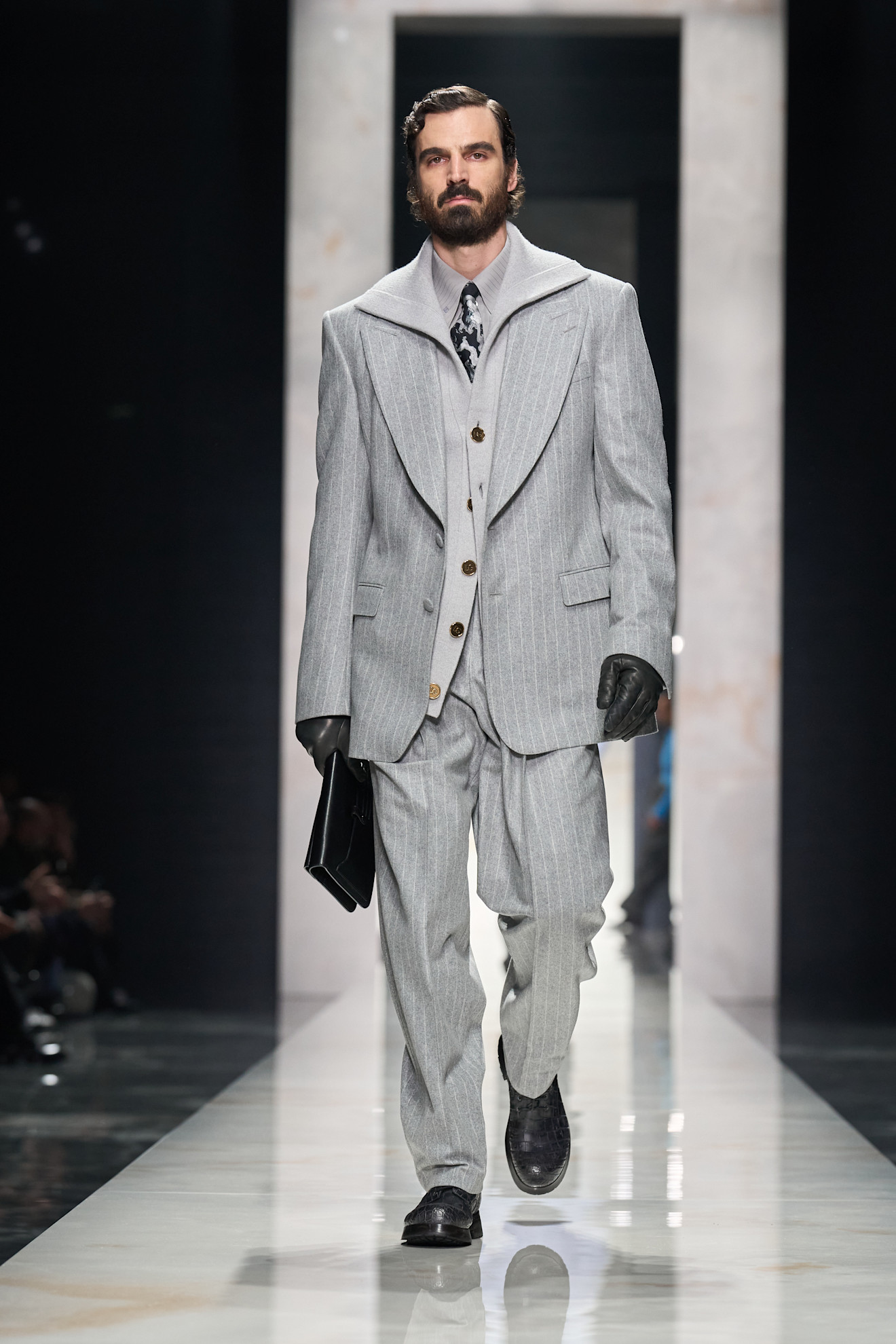 Стильный мужской костюм в светло-сером цвете с полосками, дополненный перчатками и сумкой, создает атмосферу элегантности