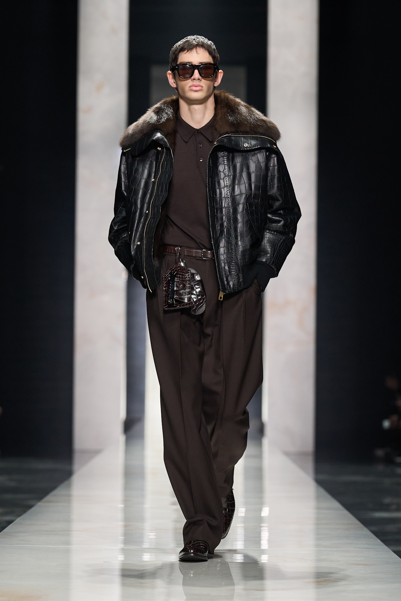 Кожаная куртка с меховым воротником в сочетании с темной футболкой и брюками, подчеркивающими стильный городской лук