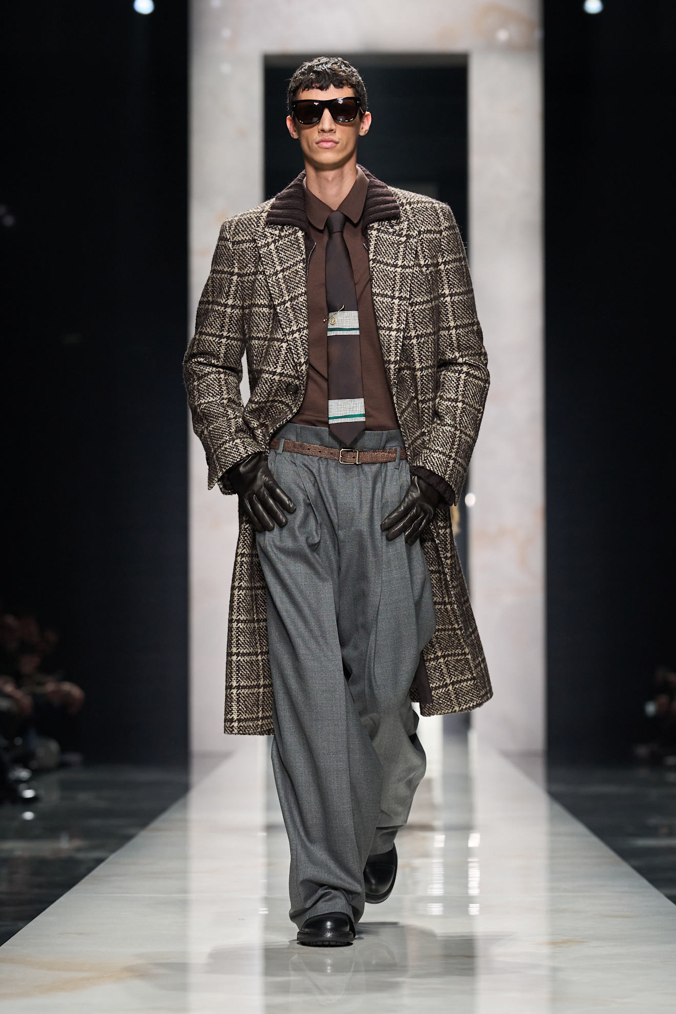 Классический длинный пальто в клетку с темной рубашкой и широкими брюками, дополненный стильными аксессуарами