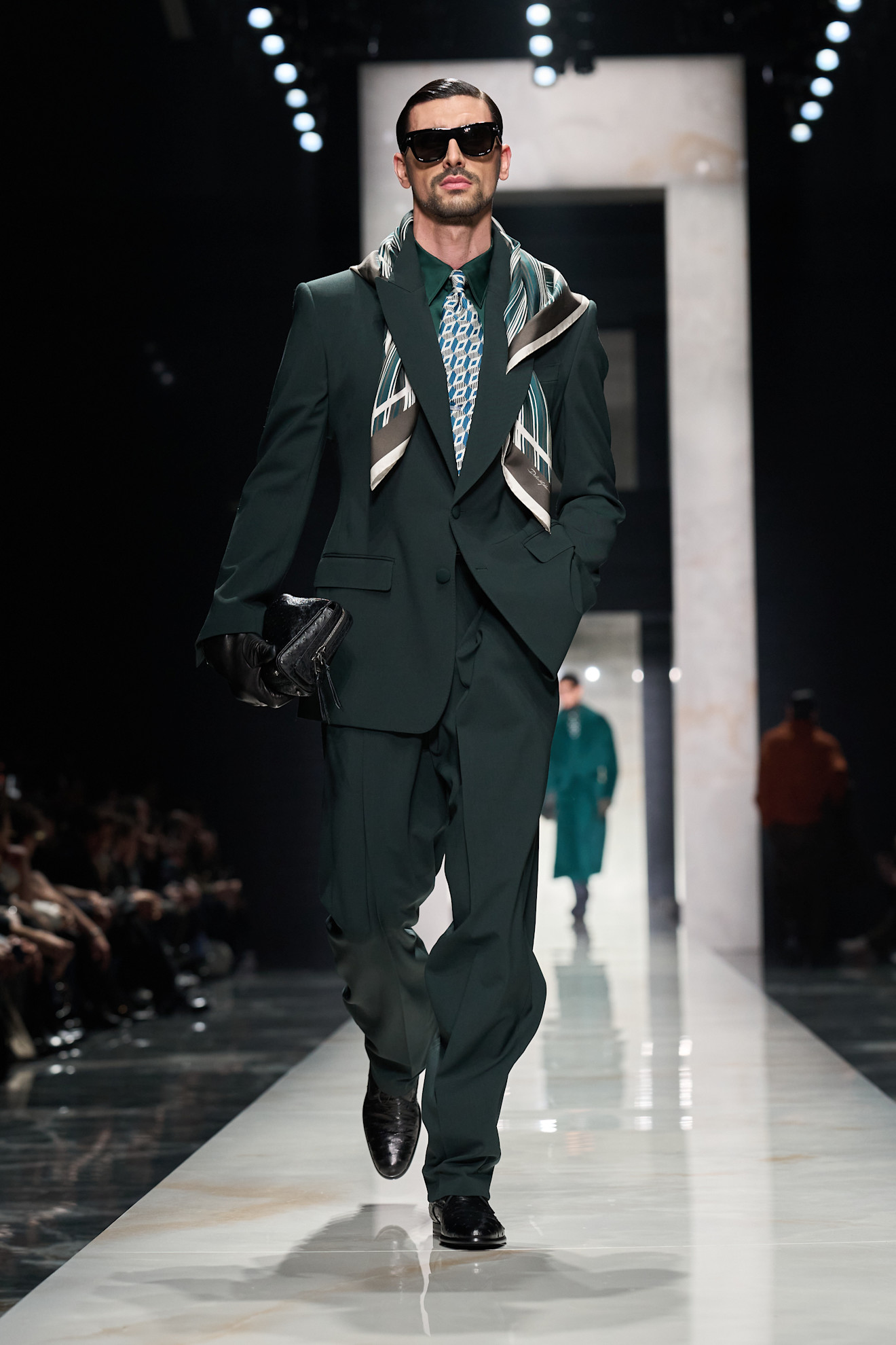 Элегантный мужской костюм глубокого зелёного цвета с узором на галстуке и стильным платком, создающим атмосферу уверенности