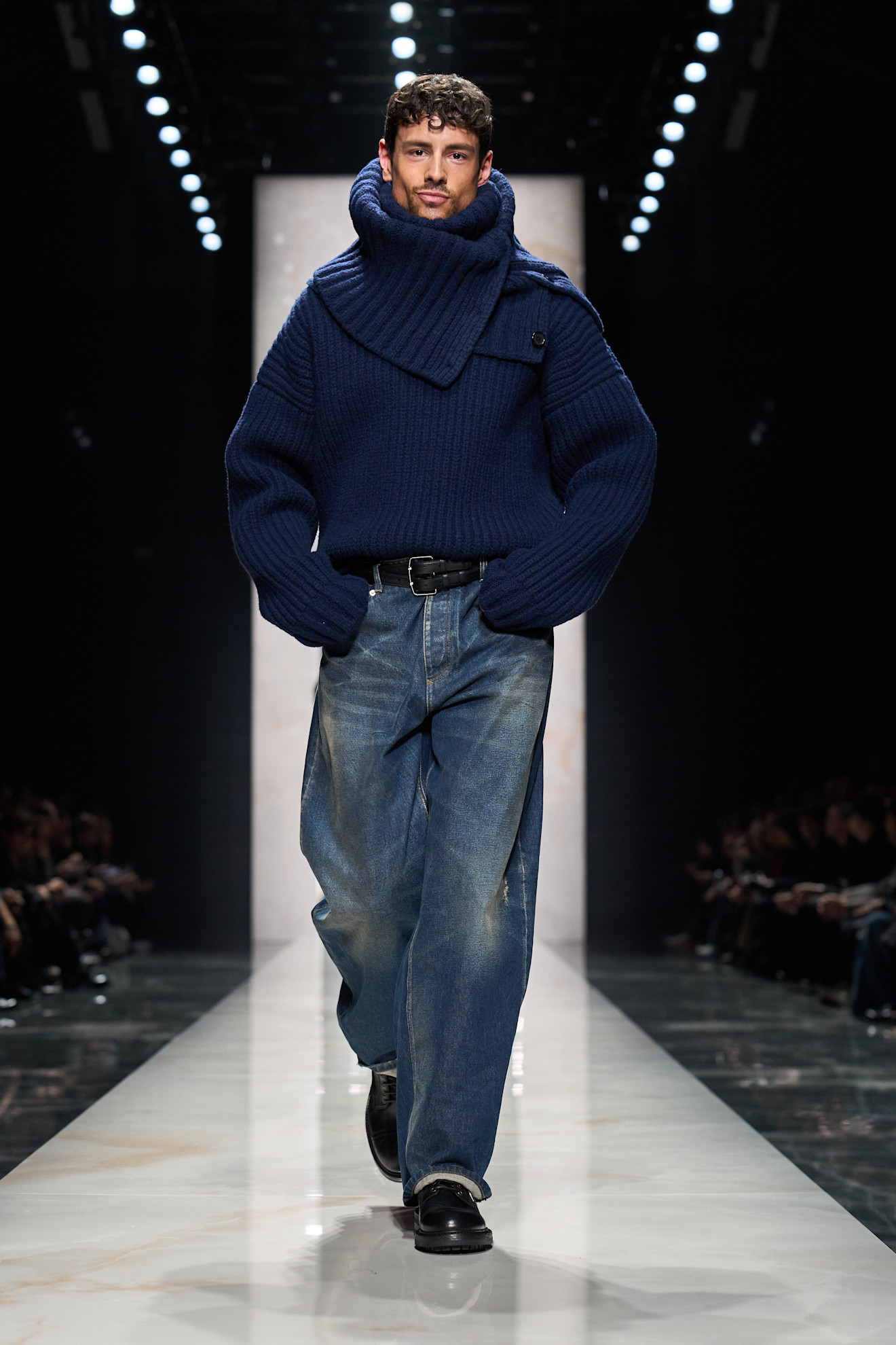 Объемный синий свитер с высоким воротником и свободные джинсы создают уютный и стильный образ для холодной погоды