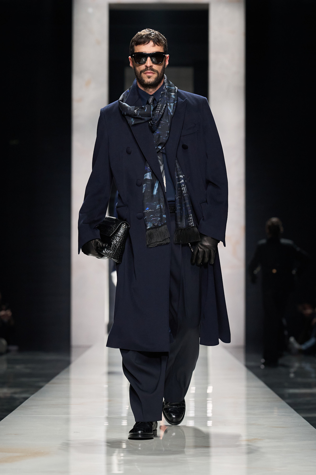 Элегантный образ в темно-синем пальто с шарфом, дополненный стильными очками и кожаной сумкой