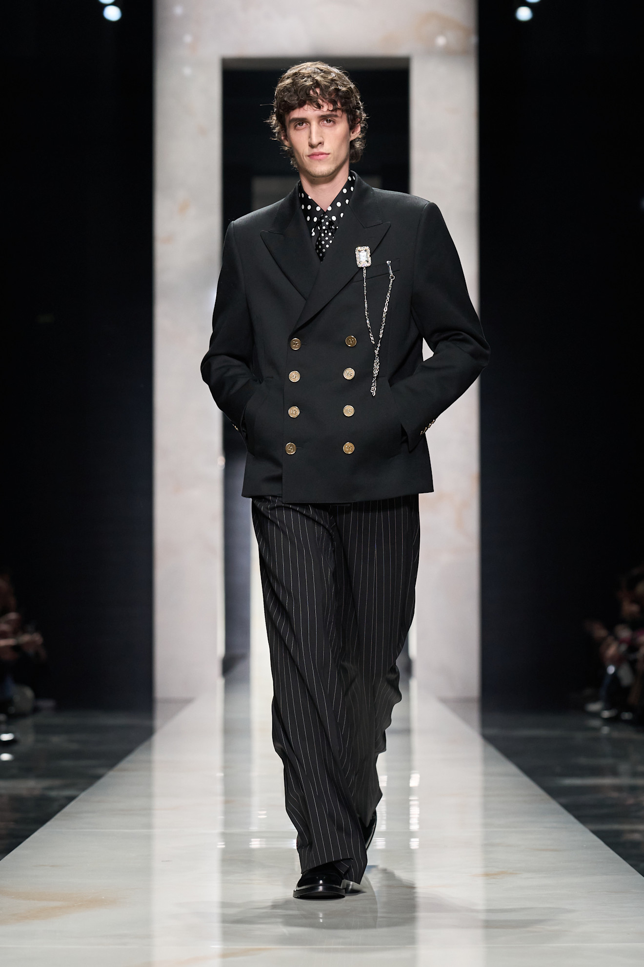 Элегантный черный пиджак с золотыми пуговицами и полосатыми брюками, создающий стильный образ для осени-зимы 2026 года