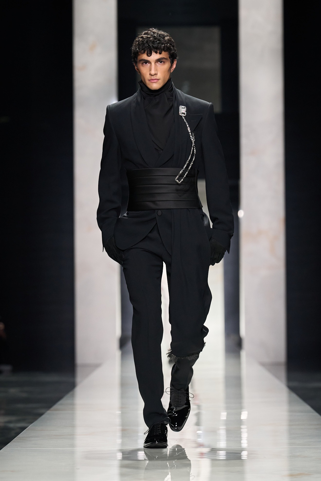 Элегантный черный наряд с акцентом на пояс и блестящей брошью, подчеркивающий силуэт и стиль