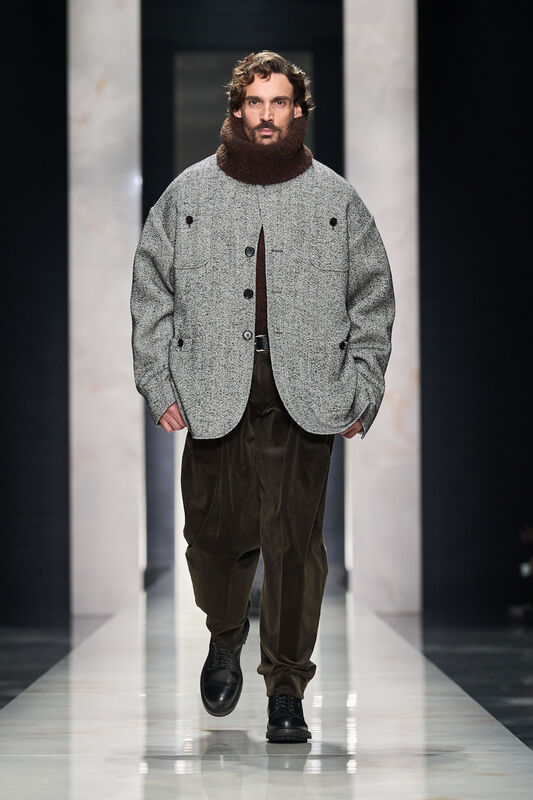 Объемная куртка из серого твида с высоким воротником и брюками из бархата, создающая уютный и современный образ