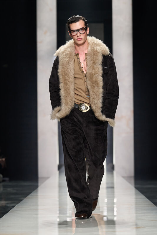 Темно-коричневая куртка с мехом и вельветовые брюки формируют роскошный образ, дополненный крупными очками