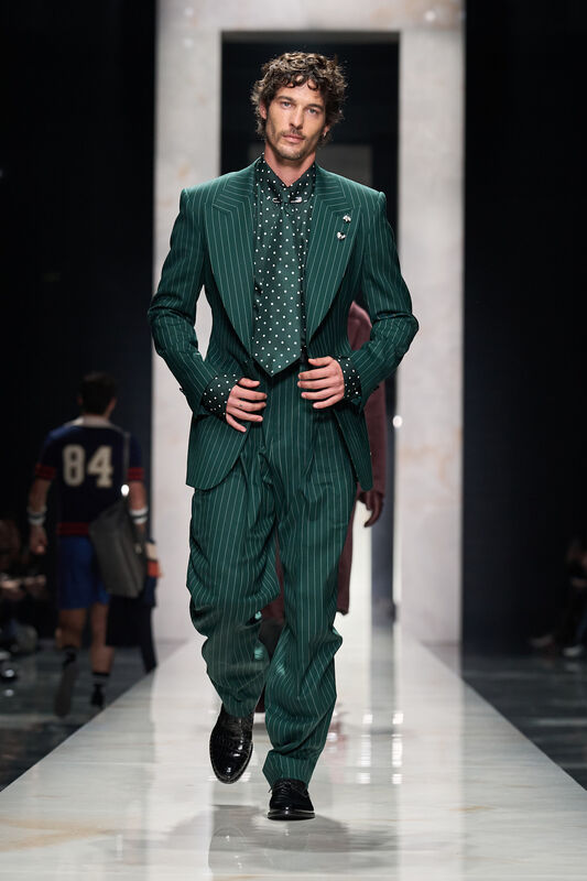 Элегантный зеленый костюм в полоску с ярким галстуком в горошек, подчеркивающий уверенность и стиль