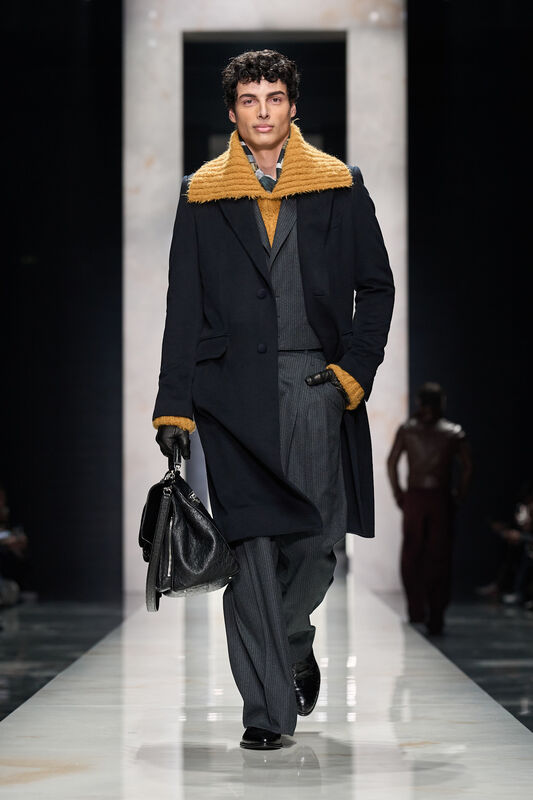 Стильный мужской плащ с ярким воротником, строгий костюм и кожаная сумка создают элегантный образ для осени 2026 года