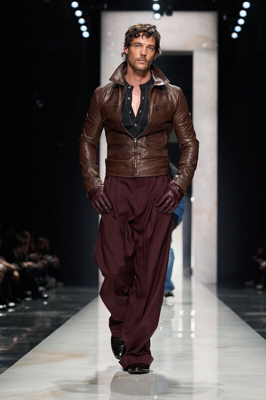 Коричневая кожаная куртка в сочетании с бордовыми брюками и черной рубашкой подчеркивают мужественность и элегантность