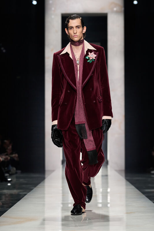 Бархатный бордовый костюм с цветочной брошью и стильным шарфом, создающий атмосферу ретро-гламура